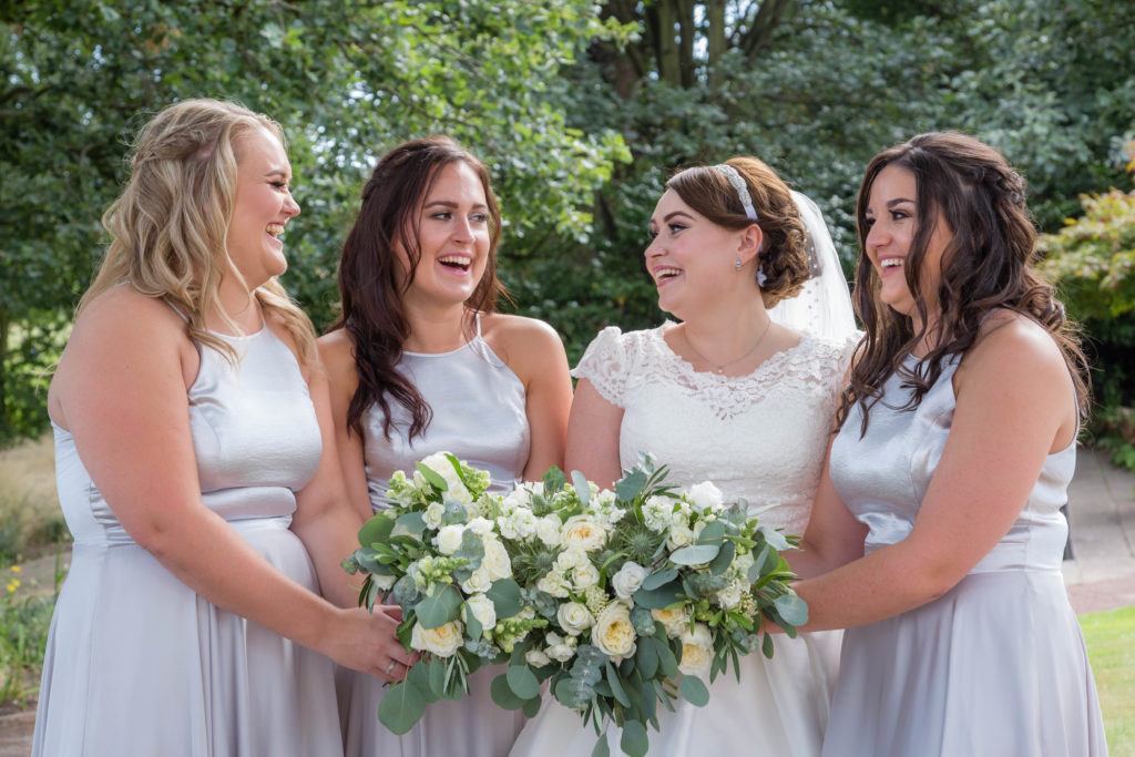 Bride and bridesmaids laugh during a wedding at Waterton Park in West Yorkshire