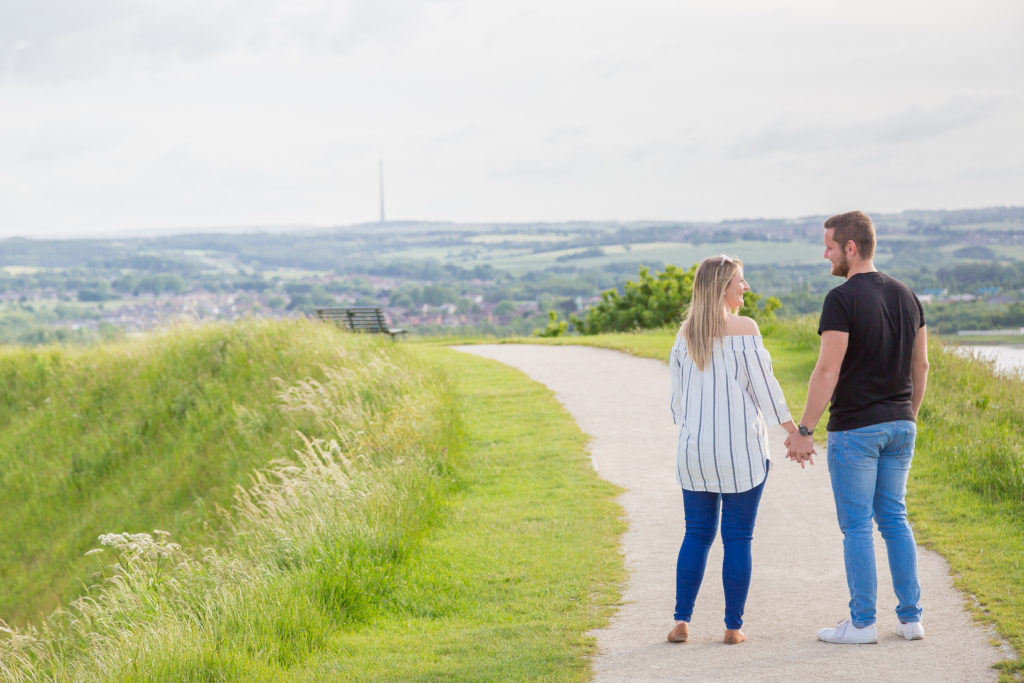 A couple hold hands and look into each other's eyes during a romantic photo shoot with Sarah Hargreaves of Sugar Photography in West Yorkshire