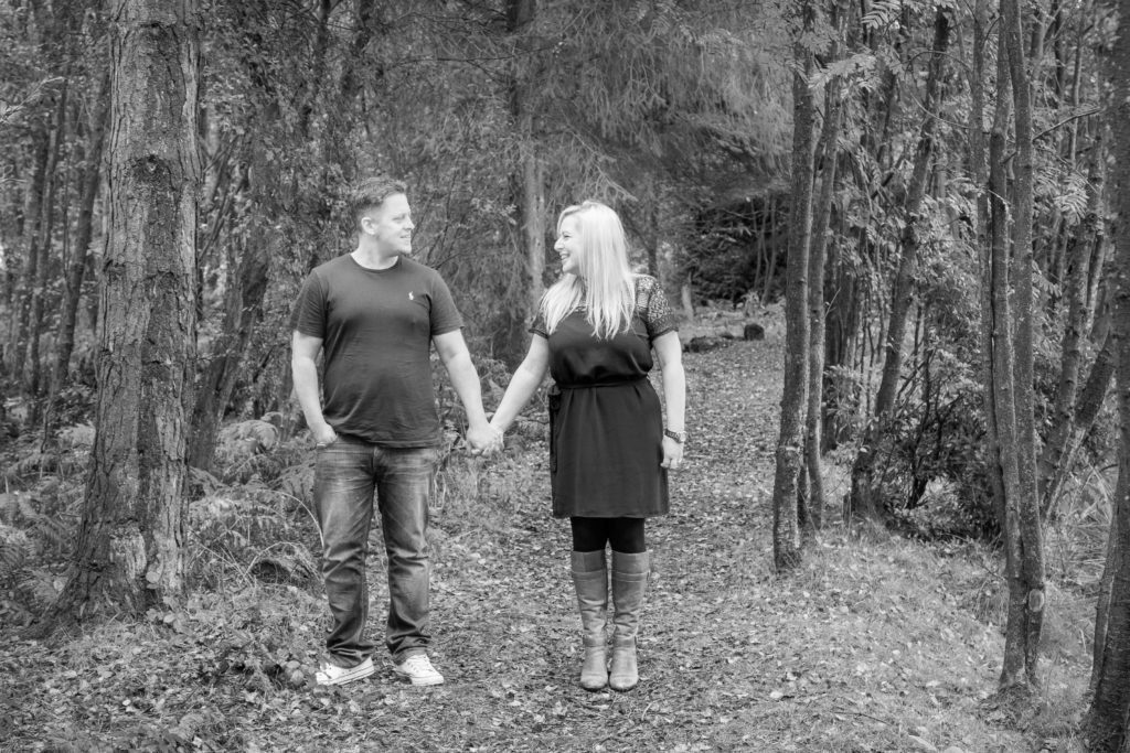 A couple hold hands in the forest a mono photo by Sarah Hargreaves of Sugar Photography